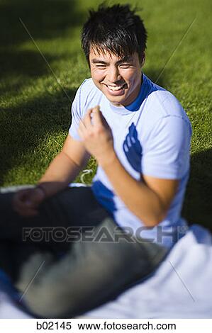Stock Photography - High angle view of a young man smiling. Fotosearch