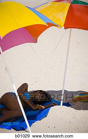 Stock Photo - High angle view of a young woman lying on the beach. Fotosearch