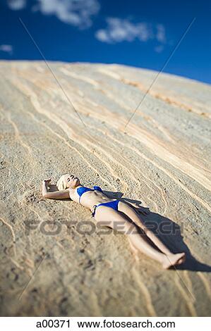 High angle view of a young woman sunbathing on a rock View Large Photo Image Stock Image - High angle view of a young woman sunbathing on a rock. Fotosearch