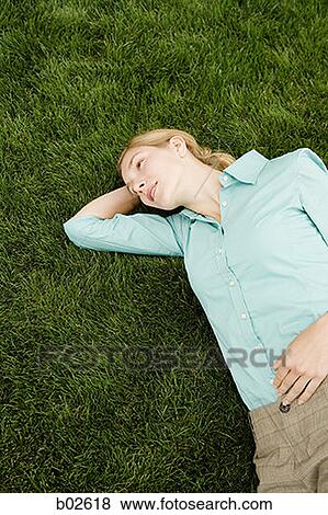 High angle view of a young woman resting on a lawn View Large Photo Image Stock Photo - High angle view of a young woman resting on a lawn. Fotosearch