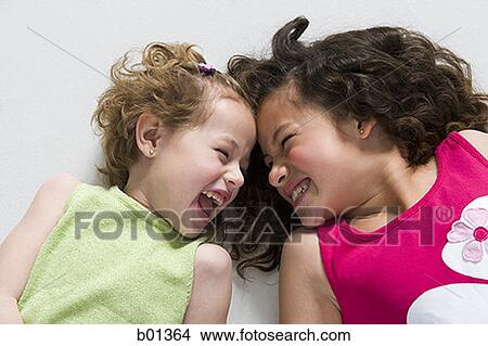 High angle view of two girls smiling at each other View Large Photo Image Picture - High angle view of two girls smiling at each other. Fotosearch