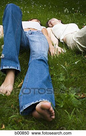 High angle view of two teenage girls lying on grass View Large Photo Image Stock Image - High angle view of two teenage girls lying on grass. Fotosearch
