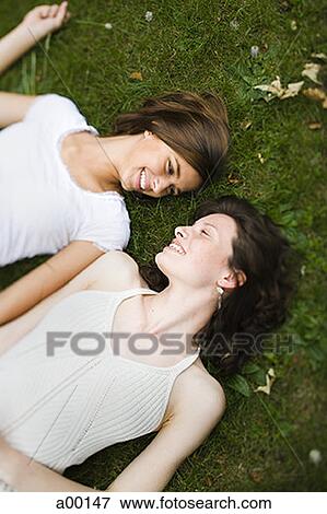 High angle view of two teenage girls lying on grass View Large Photo Image Stock Photo - High angle view of two teenage girls lying on grass. Fotosearch
