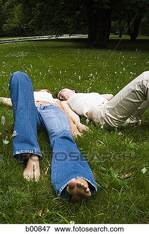 Stock Photo - High angle view of two teenage girls lying on the grass. Fotosearch