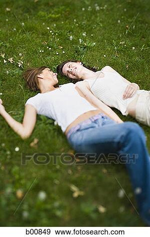 High angle view of two teenage girls lying on the grass View Large Photo Image Stock Photo - High angle view of two teenage girls lying on the grass. Fotosearch