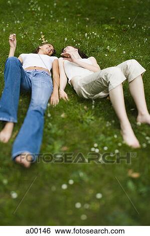 High angle view of two teenage girls lying on grass View Large Photo Image Stock Photograph - High angle view of two teenage girls lying on grass. Fotosearch
