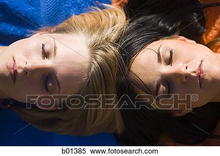 High angle view of two young women lying down View Large Photo Image Stock Photography - High angle view of two young women lying down. Fotosearch