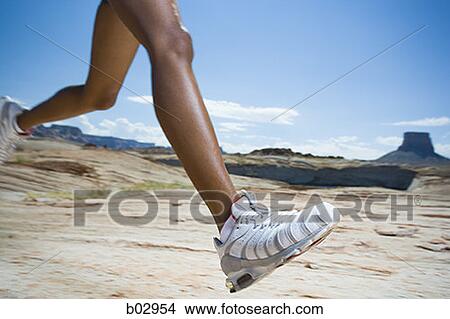 Low angle shot of a woman running in the desert View Large Photo Image Picture - Low angle shot of a woman running in the desert. Fotosearch