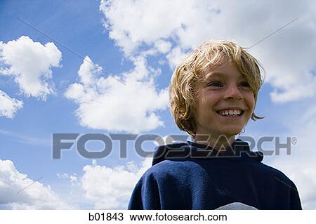Low angle view of a boy smiling View Large Photo Image Stock Image - Low angle view of a boy smiling. Fotosearch