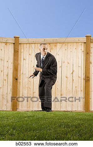 Low angle view of a businessman standing in front of a wall View Large Photo Image Stock Image - Low angle view of a businessman standing in front of a wall. Fotosearch
