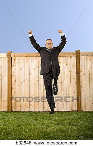 Low angle view of a businessman standing on one leg View Large Photo Image Stock Photograph - Low angle view of a businessman standing on one leg. Fotosearch
