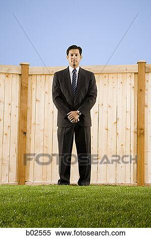 Low angle view of a businessman standing in front of a wall View Large Photo Image Stock Photography - Low angle view of a businessman standing in front of a wall. Fotosearch