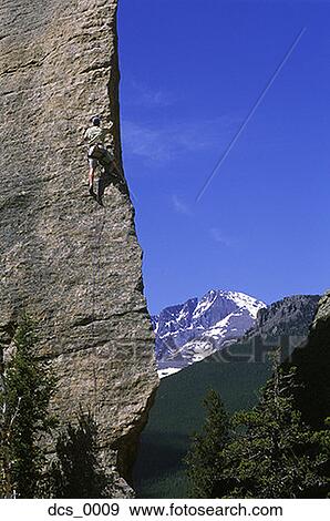 Stock Photo - Low angle view of a man rock climbing. Fotosearch