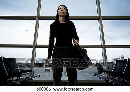 Low angle view of a mid adult woman standing at an airport lounge View Large Photo Image Stock Photography - Low angle view of a mid adult woman standing at an airport lounge. Fotosearch
