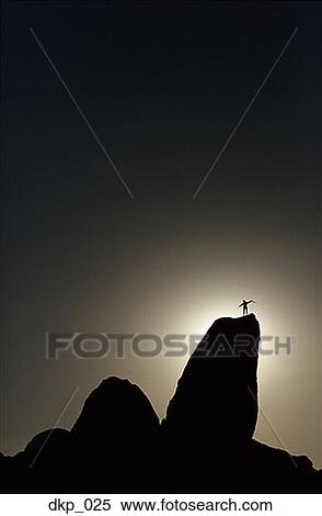 Low angle view of a silhouette of a person standing on a mountain peak View Large Photo Image Stock Photography - Low angle view of a silhouette of a person standing on a mountain peak. Fotosearch