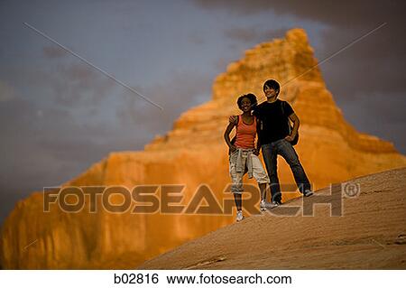 Stock Photograph - Low angle view of a young couple standing. Fotosearch
