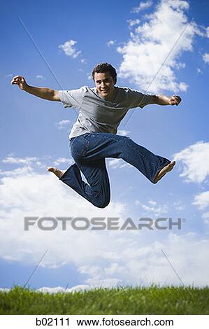 Low angle view of a young man jumping View Large Photo Image Stock Image - Low angle view of a young man jumping. Fotosearch