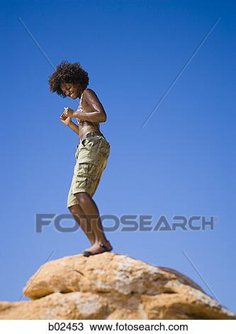 Low angle view of a young woman dancing on a rock View Large Photo Image Stock Image - Low angle view of a young woman dancing on a rock. Fotosearch