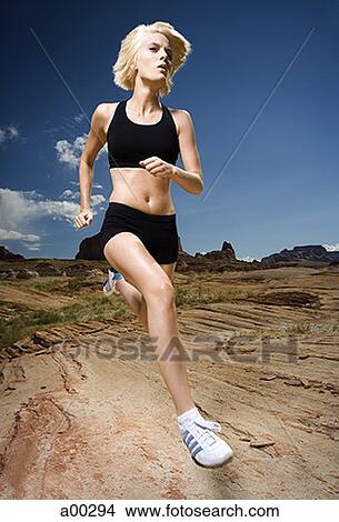 Low angle view of a young woman jogging View Large Photo Image Picture - Low angle view of a young woman jogging. Fotosearch