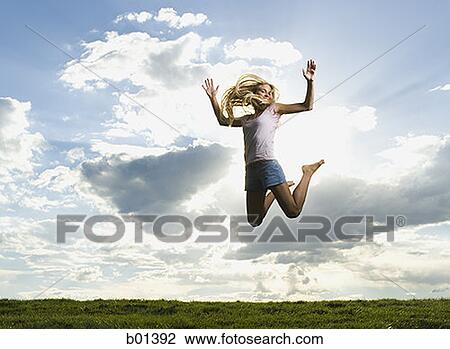 Low angle view of a young woman jumping View Large Photo Image Stock Image - Low angle view of a young woman jumping. Fotosearch