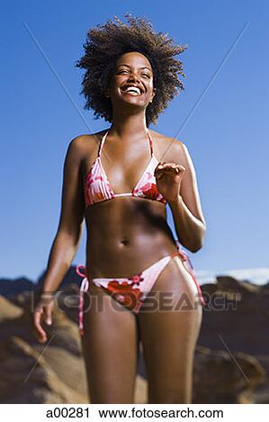 Stock Image - Low angle view of a young woman laughing. Fotosearch