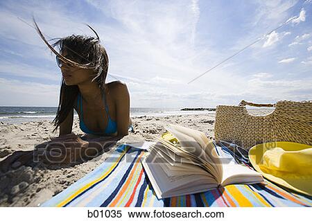 Low angle view of a young woman lying on the beach View Large Photo Image Stock Photography - Low angle view of a young woman lying on the beach. Fotosearch