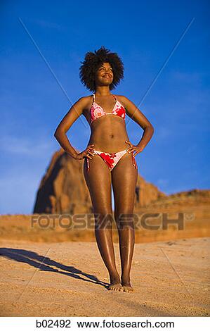 Low angle view of a young woman standing View Large Photo Image Stock Image - Low angle view of a young woman standing. Fotosearch