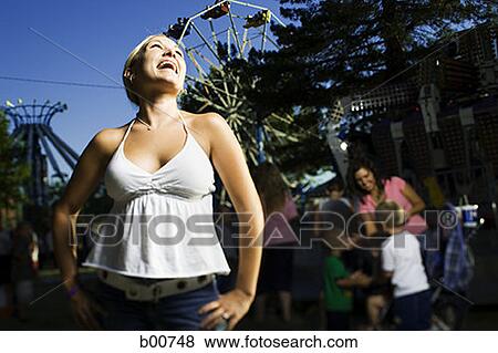 Low angle view of a young woman laughing in an amusement park View Large Photo Image Stock Photo - Low angle view of a young woman laughing in an amusement park. Fotosearch