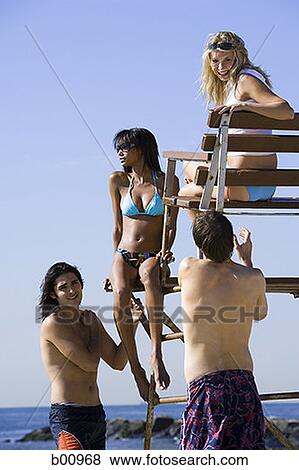 Low angle view of four young people on the beach View Large Photo Image Stock Photo - Low angle view of four young people on the beach. Fotosearch