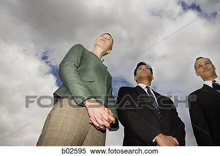 Low angle view of two businessmen and a businesswoman standing View Large Photo Image Stock Photography - Low angle view of two businessmen and a businesswoman standing. Fotosearch