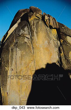 Low angle view of two people climbing up a rock face View Large Photo Image Stock Image - Low angle view of two people climbing up a rock face. Fotosearch