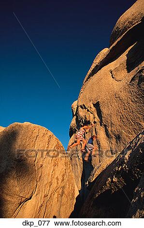 Low angle view of two people jumping over a gap between rocks View Large Photo Image Stock Photo - Low angle view of two people jumping over a gap between rocks. Fotosearch