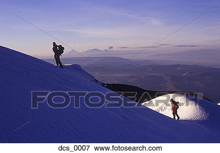 Stock Photo - Low angle view of two people trekking up a snow covered mountain. Fotosearch