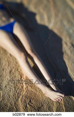 Low section view of a young woman lying on a rock View Large Photo Image Stock Photo - Low section view of a young woman lying on a rock. Fotosearch