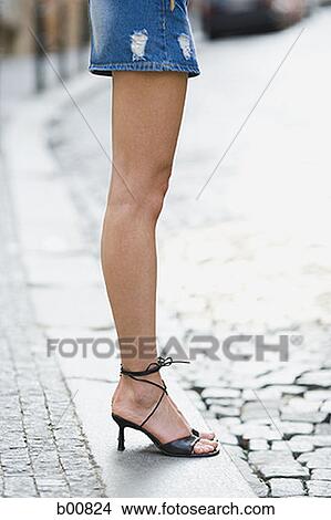 Low section view of a young woman standing View Large Photo Image Picture - Low section view of a young woman standing. Fotosearch