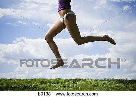 Low section view of a young woman jumping in the air View Large Photo Image Stock Image - Low section view of a young woman jumping in the air. Fotosearch