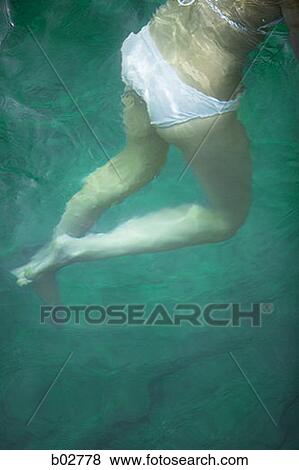 Low section view of a young woman swimming View Large Photo Image Stock Photo - Low section view of a young woman swimming. Fotosearch