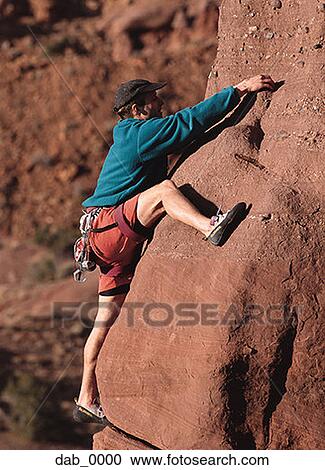 Stock Image - Man rock climbing. Fotosearch