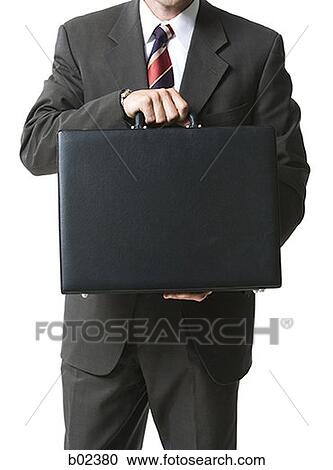 Mid section view of a businessman holding a briefcase View Large Photo Image Stock Image - Mid section view of a businessman holding a briefcase. Fotosearch