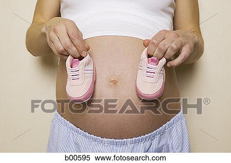 Mid section view of a pregnant woman holding a pair of shoes View Large Photo Image Stock Photography - Mid section view of a pregnant woman holding a pair of shoes. Fotosearch