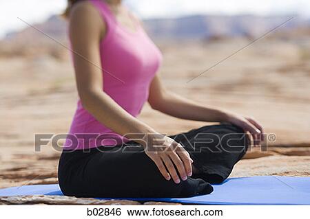 Mid section view of a young woman meditating View Large Photo Image Stock Photograph - Mid section view of a young woman meditating. Fotosearch