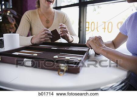 Mid section view of two women playing backgammon in a restaurant View Large Photo Image Picture - Mid section view of two women playing backgammon in a restaurant. Fotosearch