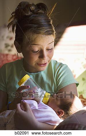 Mother feeding her baby girl a bottle of milk View Large Photo Image Stock Image - Mother feeding her baby girl a bottle of milk. Fotosearch