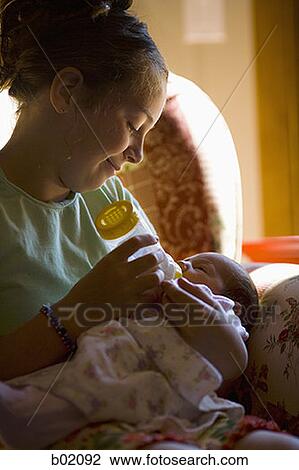 Mother feeding her baby girl a bottle of milk View Large Photo Image Stock Image - Mother feeding her baby girl a bottle of milk. Fotosearch