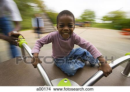 Picture - Portrait of a boy sitting on a merry-go-round. Fotosearch