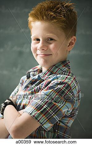 Stock Photo - Portrait of a boy standing in a classroom. Fotosearch