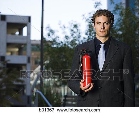 Portrait of a businessman holding a fire extinguisher View Large Photo Image Stock Photo - Portrait of a businessman holding a fire extinguisher. Fotosearch