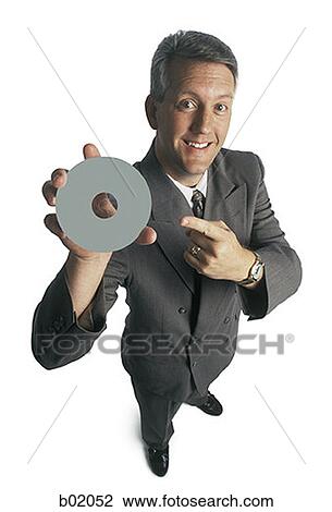 Portrait of a businessman holding and pointing to a compact disc View Large Photo Image Stock Image - Portrait of a businessman holding and pointing to a compact disc. Fotosearch