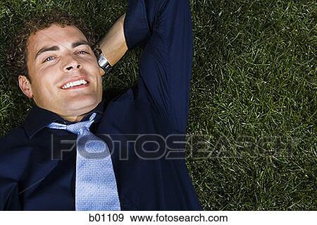 Portrait of a businessman lying on a lawn View Large Photo Image Stock Photo - Portrait of a businessman lying on a lawn. Fotosearch