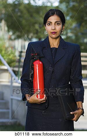Portrait of a businesswoman holding a fire extinguisher View Large Photo Image Stock Photo - Portrait of a businesswoman holding a fire extinguisher. Fotosearch
